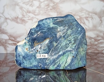 Puede incluir: Una piedra grande de forma irregular azul y verde con vetas blancas. La piedra pesa 2,8 kg.