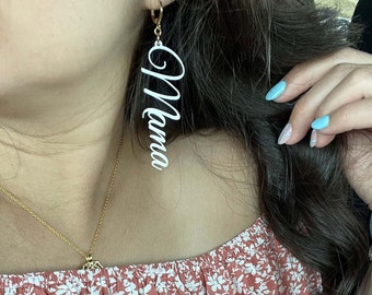May include: White acrylic earrings with the word "Mama" written in cursive.
