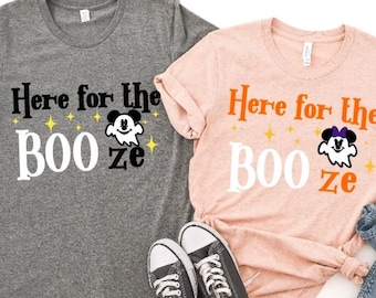 Op de afbeelding: Twee grijze en roze t-shirts met de tekst "Here for the Booze" en een cartoon-spook met Mickey Mouse-oren.