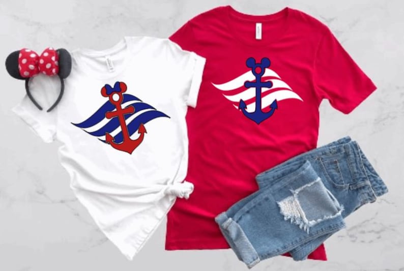 May include: Two t-shirts with a red and blue anchor and Mickey Mouse ears on a white wave design. The shirt on the left is white and the shirt on the right is red.