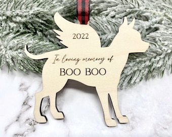 May include: Wooden Christmas ornament shaped like a dog with the text "In loving memory of BOO BOO" and the year "2022" engraved on it.