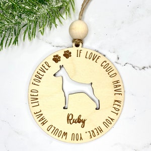 May include: A wooden Christmas ornament with a silhouette of a dog and the text "If love could have kept you here you would have lived forever". The dog's name "Ruby" is also engraved on the ornament.