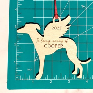 Wooden Greyhound Memorial Ornament in red ribbon.  The ornament is 4.2 inches wide and 3.63 inches tall.