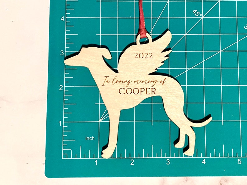 Wooden Greyhound Memorial Ornament in red ribbon.  The ornament is 4.2 inches wide and 3.63 inches tall.