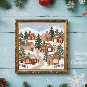 Peut inclure: Une broderie au point de croix encadrée représentant un village d'hiver avec des maisons enneigées, des sapins et un chemin sinueux. L'œuvre est dans un cadre doré. Les mots "Merry Xmas Christmas" sont écrits en blanc sur le côté droit.