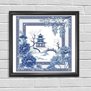 May include: Blue and white cross-stitch embroidery design featuring a traditional Chinese pagoda, flowering trees, and a bridge. The design is framed in a black frame.