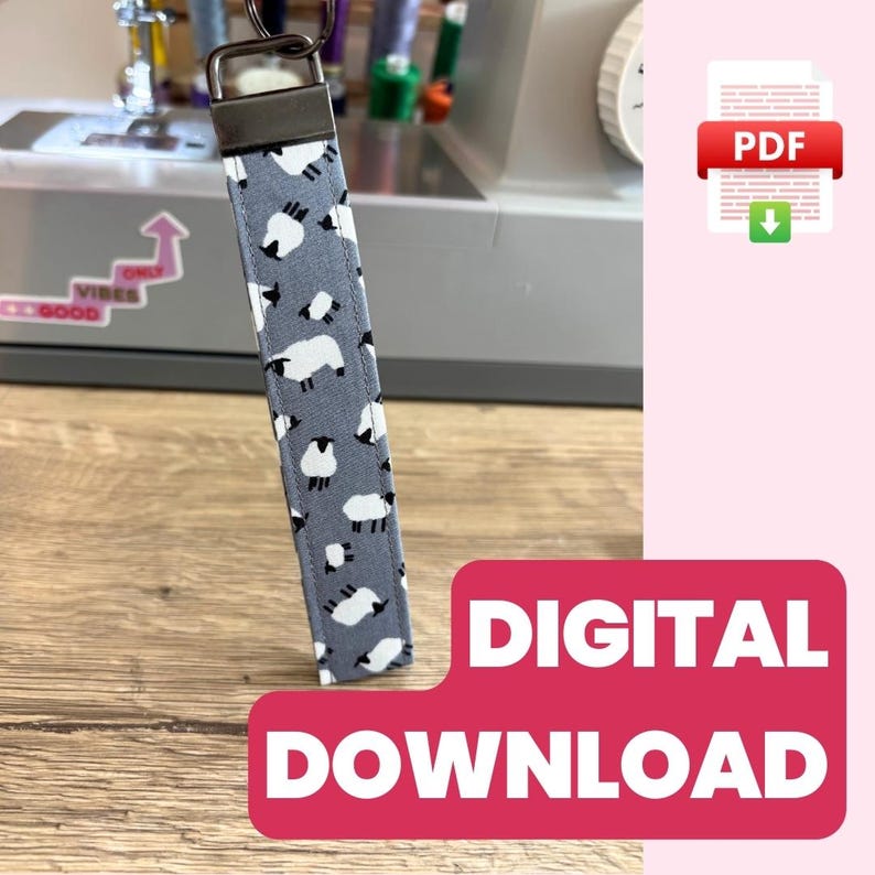 May include: A gray and white fabric keychain with a pattern of sheep. The keychain is attached to a silver key ring. The image includes the text "DIGITAL DOWNLOAD" and "PDF".