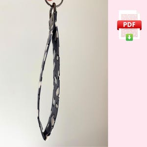 May include: A black and white patterned key chain with a silver key ring.