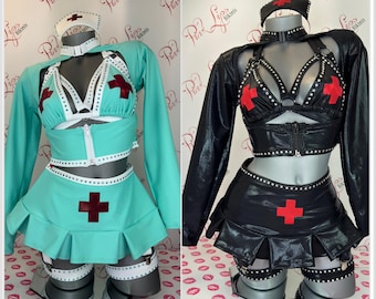 Puede incluir: Dos trajes de enfermera, uno en azul verdoso y otro en negro, con una cruz roja en la falda y un ribete blanco. Ambos trajes tienen un sujetador con un arnés blanco y una chaqueta a juego.