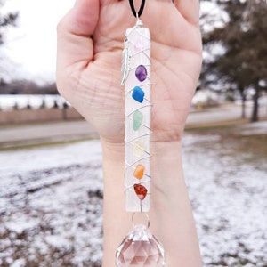 Puede incluir: Una varita de selenita blanca con una punta de cristal en la parte inferior. La varita est&aacute; envuelta con alambre y tiene siete piedras de chakra unidas. Las piedras son rosa, p&uacute;rpura, azul, verde, amarilla, naranja y roja. La varita cuelga de un cord&oacute;n negro.