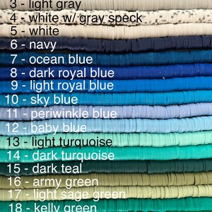 May include: A close-up of 20 rows of colourful polymer clay beads. The beads are arranged in rows from black to lime green. Each row is labelled with a number and the colour name. The beads are all the same size and shape.