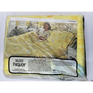 May include: A yellow and white patterned sheet set with butterflies and the text "No-Iron Percale Pequot Flutter-Bye" on the packaging. The sheet set is made of 65% Dacron and 35% cotton.