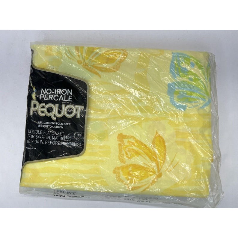 May include: A yellow and white double flat sheet with a butterfly pattern. The sheet is packaged in plastic and has a label that reads "No-Iron Percale Pequot 45% Dacron Polyester 35% Cotton/Coton Double Flat Sheet for 54x76 in. Mattress (81x104 in. Before Trimming)"