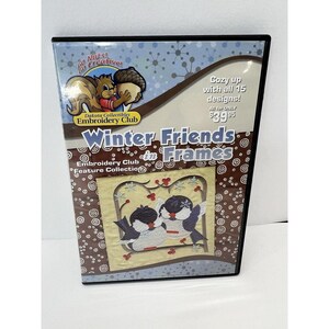 May include: A DVD case with a brown background and white snowflakes. The case features a picture of two blue birds on a branch with red berries. The text on the case reads "Winter Friends in Frames" and "Embroidery Club Feature Collection".