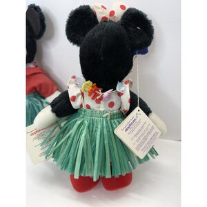 Puede incluir: Dos mu&ntilde;ecas de peluche de Minnie Mouse. Cada mu&ntilde;eca lleva una camiseta blanca con lunares rojos, una falda de hierba verde y un lazo rojo. Las mu&ntilde;ecas tienen pelo negro y zapatos rojos. Cada mu&ntilde;eca tiene una etiqueta.