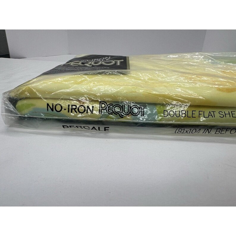 May include: A yellow and blue patterned double flat sheet in a plastic package. The package says "No-Iron Pequot Percale Double Flat Sheet (81x104 in. before laundering)"