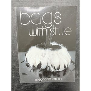 May include: A book titled "bags with style" with a black and white cover. The cover features a close-up of a white, feathery bag with black accents. The author's name, Stephanie Kimura, is printed at the bottom.
