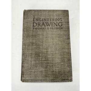 May include: A vintage book titled "ENGINEERING DRAWING" by Thomas E. French. The book has a textured, olive-green cover with the title and author's name printed in dark letters. The book appears to be in good condition.