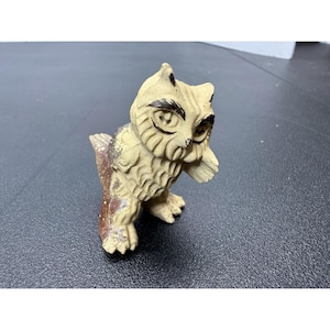 May include: A small, vintage owl figurine with a cream-colored body and brown accents. The owl has detailed facial features, including large eyes and a textured chest. The figurine is made of a ceramic-like material.