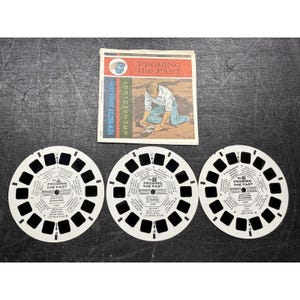 May include: Three white View-Master reels with black square viewing holes and text, alongside a small booklet. The booklet cover reads "PROBING the PAST" and "ARCHAEOLOGY". The reels are labeled "PROBING THE PAST".