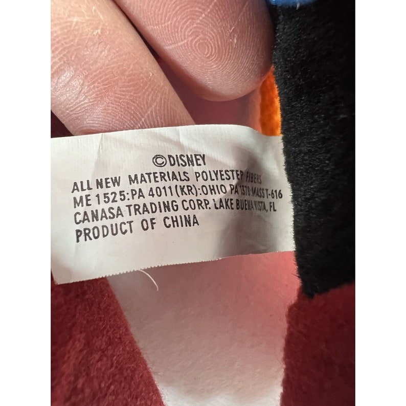 May include: White tag with black text that reads "DISNEY ALL NEW MATERIALS POLYESTER FIBERS ME 1525:PA 4011 (KR): OHIO PA 1378 MASS T-616 CANASA TRADING CORP. LAKE BUENA VISTA, FL PRODUCT OF CHINA"