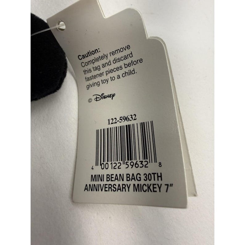 Peut inclure: Une &eacute;tiquette blanche avec le logo Disney et le texte "MINI BEAN BAG 30TH ANNIVERSARY MICKEY 7"" est attach&eacute;e &agrave; un jouet en peluche noir et blanc. L'&eacute;tiquette comprend un avertissement et un code-barres.