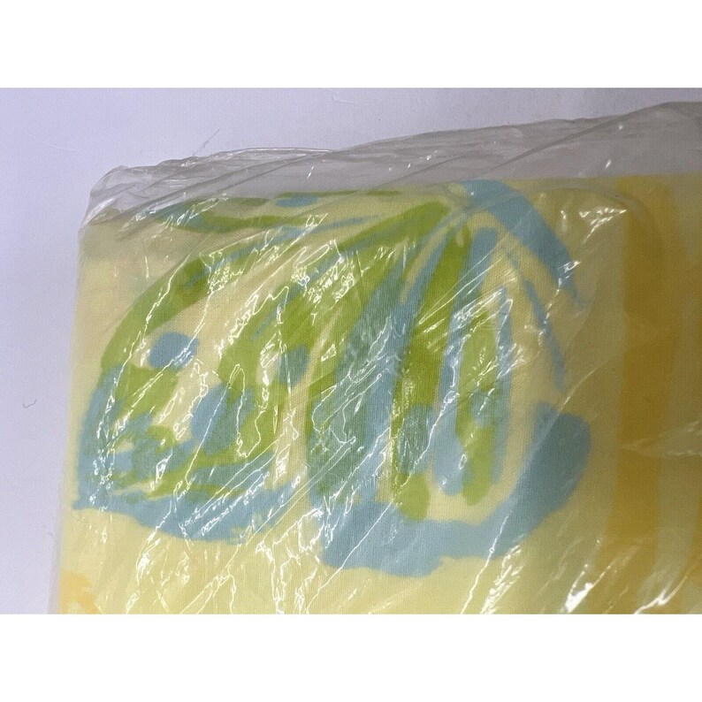 May include: A yellow, green and blue patterned blanket wrapped in plastic.