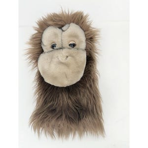 May include: A plush orangutan puppet with a light brown face and dark brown fur. The puppet has black eyes and a soft, textured appearance. The puppet is designed to be worn on the hand.