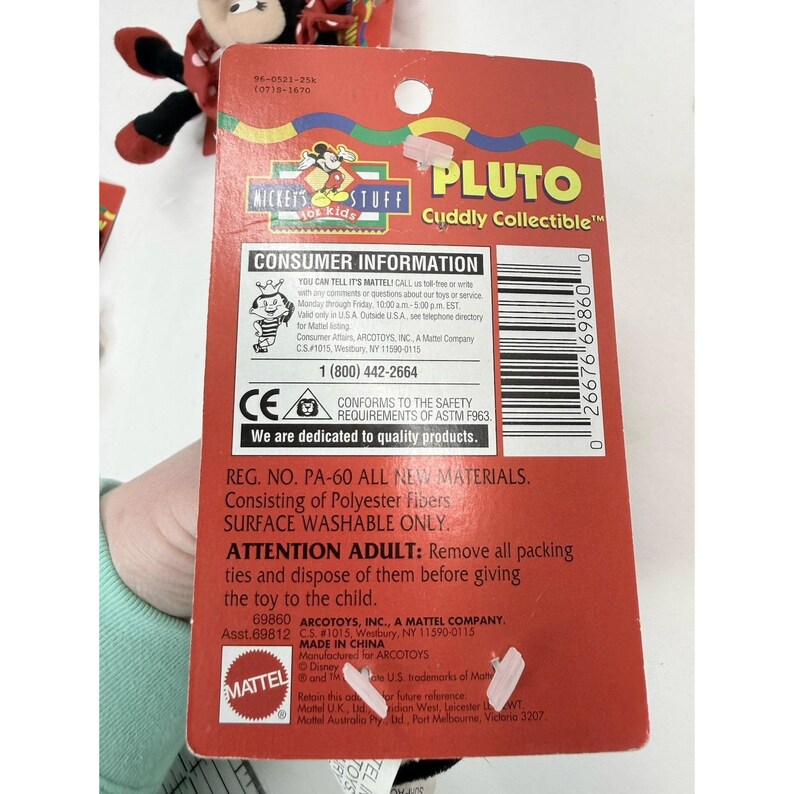 Puede incluir: Un paquete rojo del juguete Pluto Cuddly Collectible con informaci&oacute;n para el consumidor y detalles de seguridad. El paquete incluye el texto "Mickey's Stuff for Kids" y "Made in China."