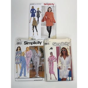 May include: A collection of vintage Simplicity sewing pattern envelopes. The patterns feature illustrations of various garments, including dresses, robes, and jackets. The envelopes display model images and pattern numbers.