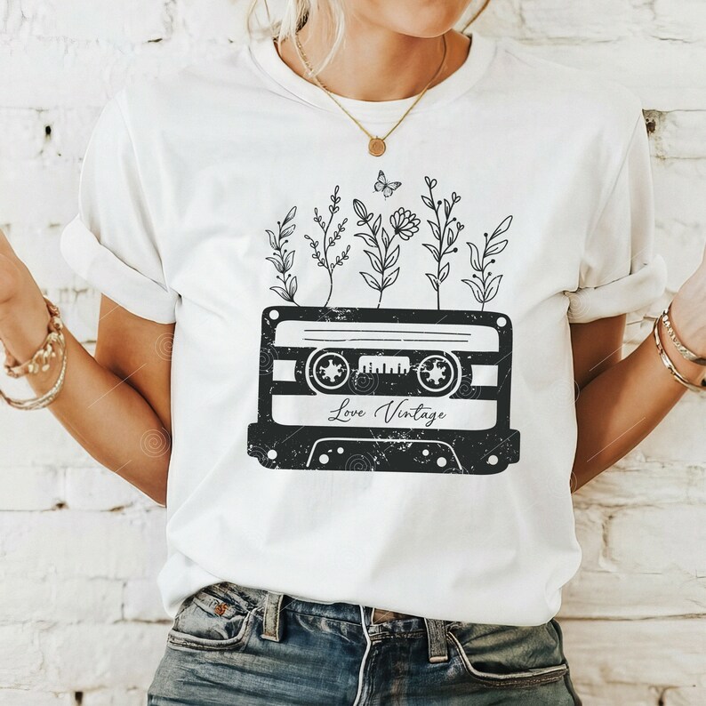 May include: White t-shirt with a black and white graphic of a cassette tape with flowers growing out of it. The text "Love Vintage" is printed on the tape.