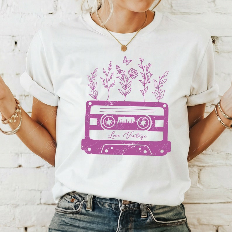 May include: White t-shirt with a pink vintage cassette tape design. The cassette tape has flowers and a butterfly growing out of it. The text "Love Vintage" is printed on the cassette tape.