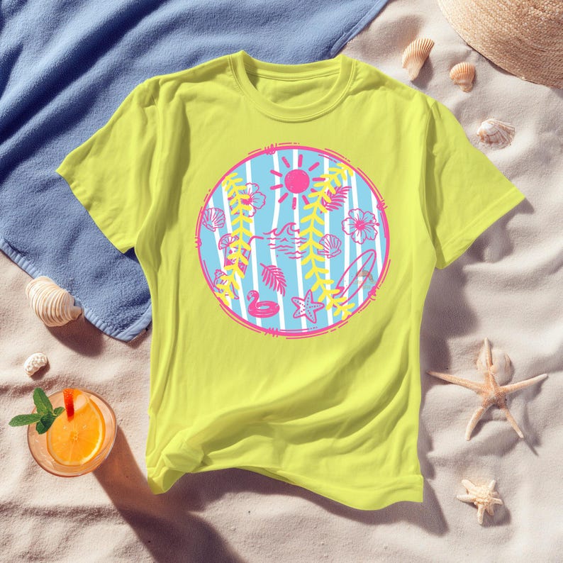 May include: A yellow t-shirt featuring a circular design with a pink sun, waves, and tropical elements like flowers, seashells, and a surfboard. The design is set against a blue and white striped background, evoking a beach theme.