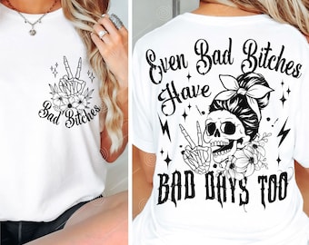 Könnte beinhalten: Weißes T-Shirt mit einem schwarzen Totenkopf-Motiv und dem Text "Even Bad Bitches Have Bad Days Too". Der Totenkopf trägt ein Bandana und macht mit seinen Skelettfingern ein Peace-Zeichen.