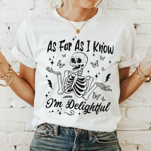 May include: White t-shirt with a black skeleton graphic and the text "As Far As I Know I'm Delightful". The skeleton is surrounded by butterflies and stars.