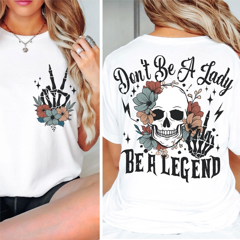 May include: White t-shirt with a skull and flowers graphic on the back. The text "Don't Be A Lady Be A Legend" is printed below the graphic. The front of the shirt has a peace sign with flowers.