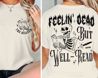 May include: A white t-shirt with a black skeleton reading a book and the text "Feelin' Dead But Well-Read". The front of the shirt has a smaller design of a book with the text "The Reader".