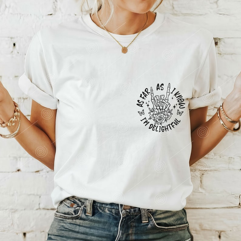 May include: White t-shirt with a black graphic print of a skeleton hand making a rock and roll sign with flowers and butterflies around it. The text reads "As far as I know I'm delightevil."