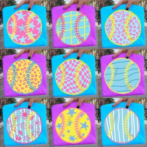 May include: A collection of tote bags in various designs. Each bag features a circular graphic resembling a baseball, with patterns like stars, leopard print, and checkered designs. The bags have a blue or purple background and are held by a hand.