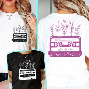 May include: A white t-shirt with a pink vintage cassette tape design featuring flowers and the text "Love Vintage".