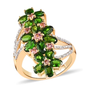 May include: A gold ring with three flower-shaped clusters of green and pink gemstones. The ring is set with small diamonds on the band.