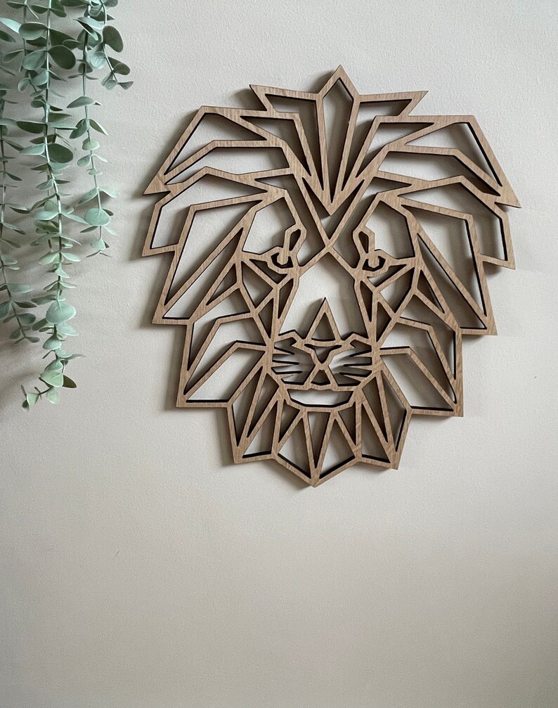 May include: Geometric wooden lion head wall decor. The lion's mane and face are made of intricate geometric shapes, creating a modern and stylish design.