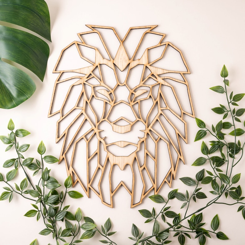 May include: Geometric wooden lion head wall decor. The lion's face is made of a series of triangles and squares, creating a modern and abstract design.