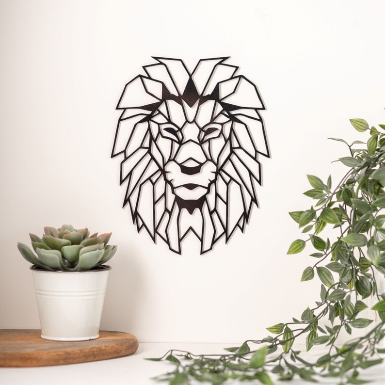 May include: Black geometric lion head wall decor. The lion's mane is made up of many triangles. The lion's face is detailed with a nose, eyes, and mouth.