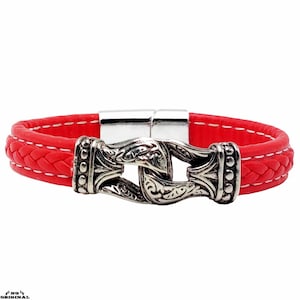 May include: A red leather bracelet with a silver, ornate clasp. The bracelet has a braided design and a magnetic closure.