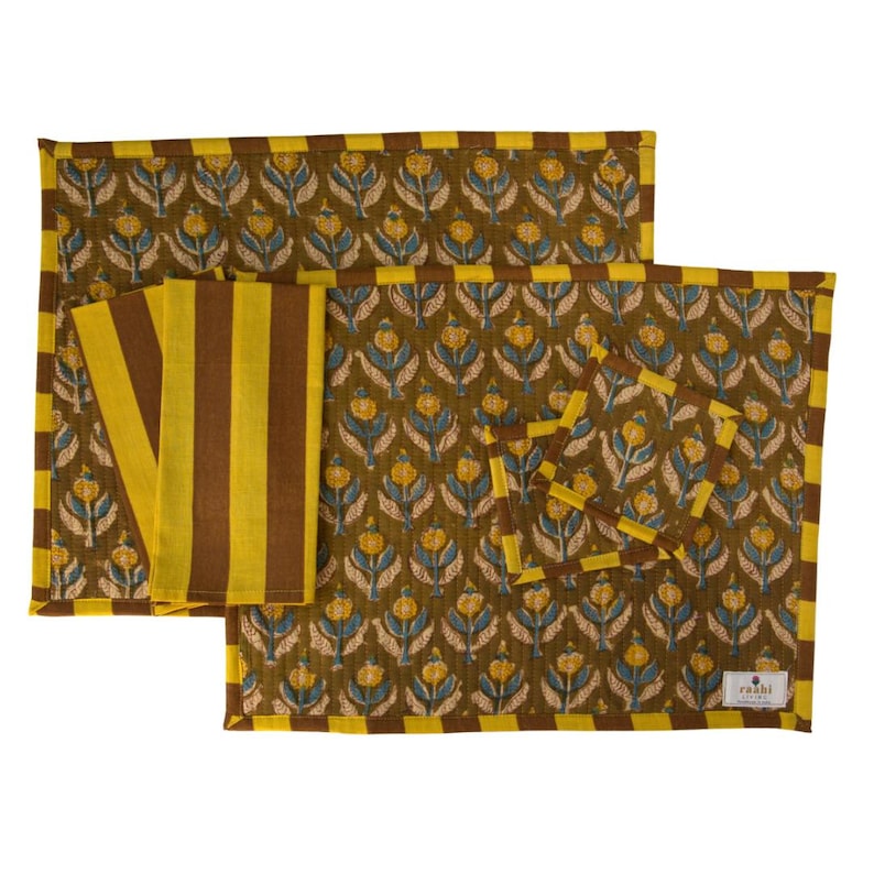 Pu&ograve; includere: Un set di tovagliette, tovaglioli e sottobicchieri verde oliva. Le tovagliette e i sottobicchieri presentano un motivo floreale giallo e blu, con un bordo giallo e marrone. I tovaglioli sono a righe gialle e marroni.