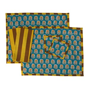 Pu&ograve; includere: Un set di tovagliette, tovaglioli e sottobicchieri turchesi con un motivo floreale. Le tovagliette e i sottobicchieri hanno un bordo giallo e marrone. I tovaglioli presentano strisce verticali gialle e marroni. Il motivo floreale &egrave; giallo e arancione.
