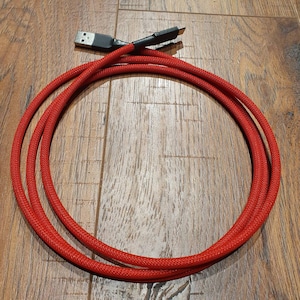 May include: Red braided cable with a USB connector on one end.