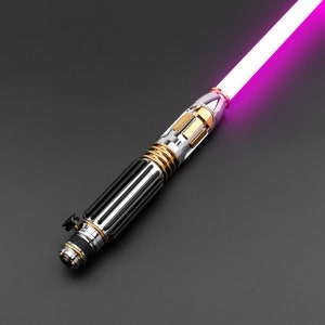 May include: A black and silver lightsaber with a gold accent and a pink blade.