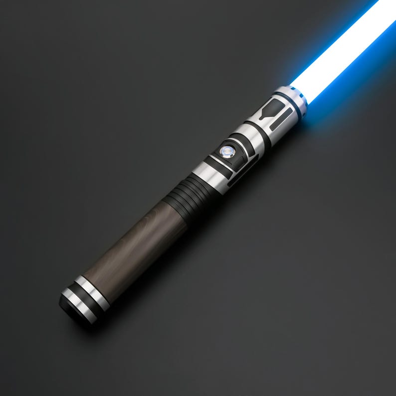 K&ouml;nnte beinhalten: Ein Lichtschwert mit einer leuchtend blauen Klinge, die aus einem Griff mit dunkelbraunem zylindrischem Schaft, schwarzen gerippten Akzenten und einem silbernen Metall-Emitter mit rundem Aktivierungsschalter und schwarzen Ausschnitten ragt.